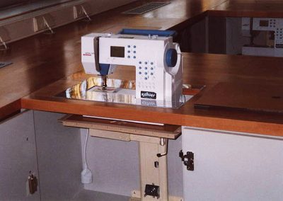 Eine Nähmaschine wird durch die geöffnete Tischplatte herausgefahren